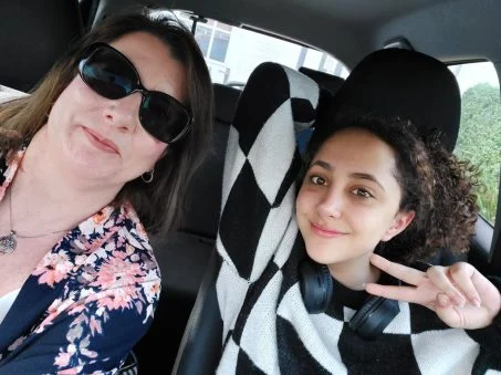 A picture of a student and their Educational Guardianship in the car. The student is happy.