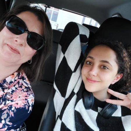 A picture of a student and their Educational Guardianship in the car. The student is happy.